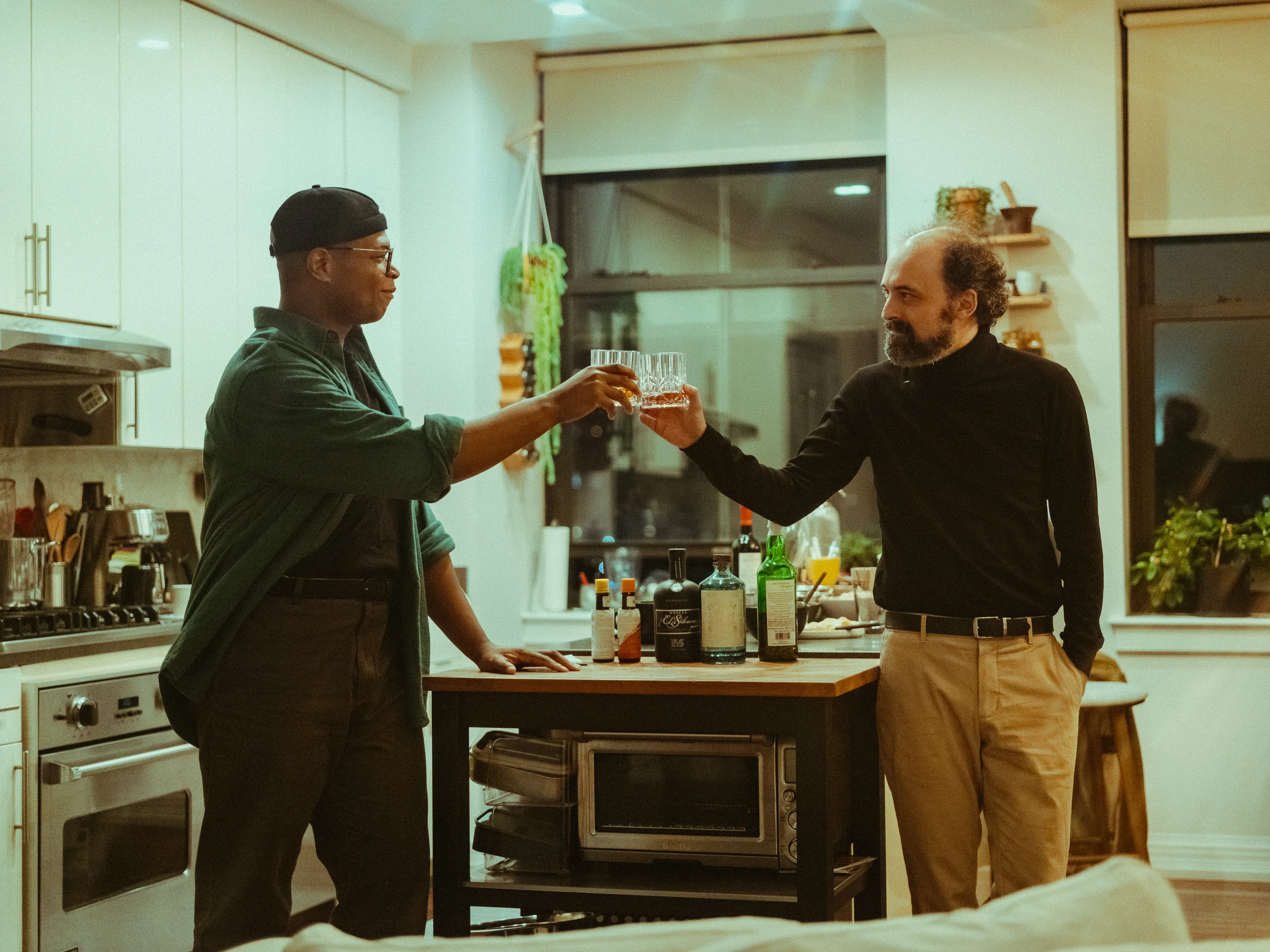 Two actors clinking glasses during a performance in a New York apartment
